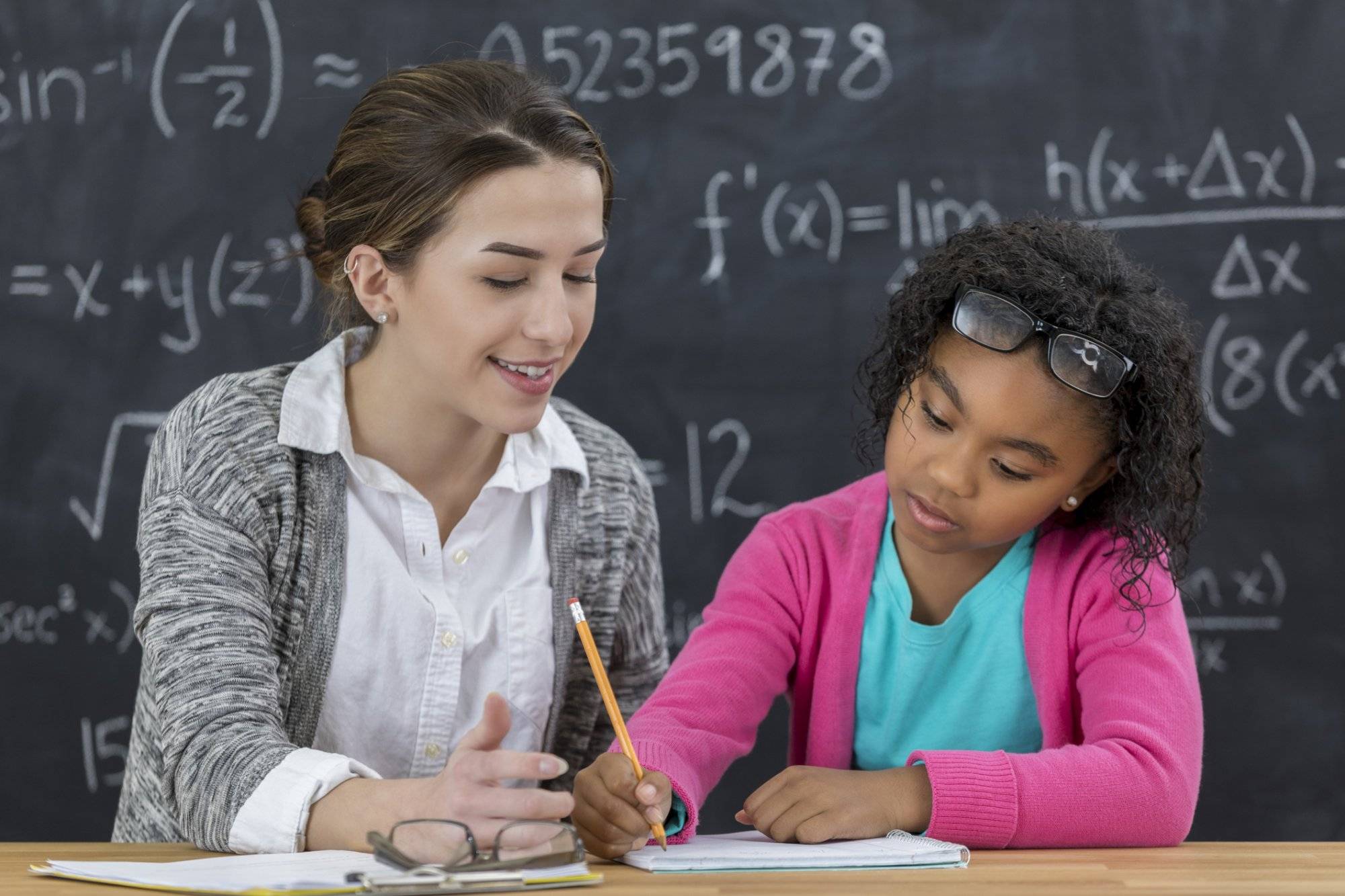 Math teacher helps elementary schoolgirl with math assignment STAAR Testing Practice Made Easy with Mathnasium of East Round Rock
